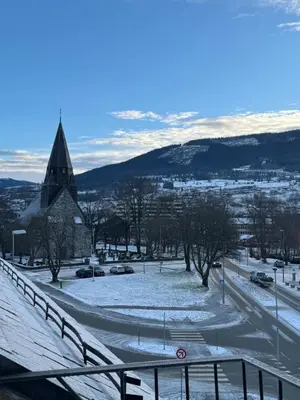 a snow covered street with a church and a road at 1 minute to the train station - Exclusive Penthouse! in Vossevangen