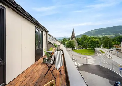 a balcony with a view of a city at 1 minute to the train station - Exclusive Penthouse! in Vossevangen