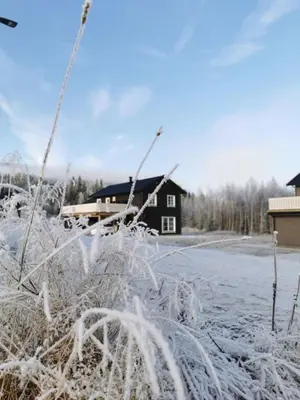 a snow covered field with a house in the background at Trysil Central Villa in Trysil