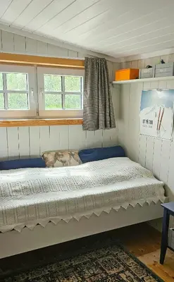 a bed in a small room with two windows at Family Cabin Near Rallarvegen And Geilo in Ustaoset