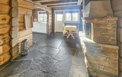 a living room with a stone wall and a table at Cozy Home In Eggedal With Wifi in Eggedal