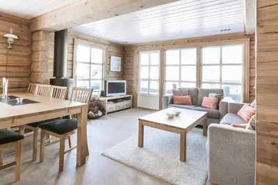 a kitchen and living room with a table and chairs at Stranda Fjellgrend 3 bedrooms - 68B in Stranda