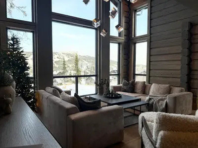 a large living room with couches and a large window at New exclusive cabin - panoramic view with ski in-out, Kvitfjell Varden in Ringebu