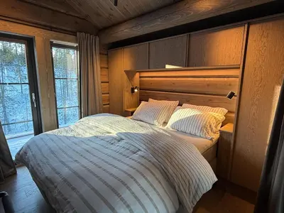 a bedroom with a large bed with a wooden headboard at New exclusive cabin - panoramic view with ski in-out, Kvitfjell Varden in Ringebu