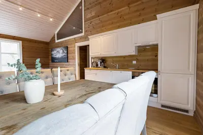 a kitchen with white cabinets and a white couch at Stranda Fjellgrend 3 bedrooms and loft - 80D in Stranda