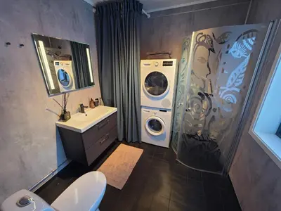 a bathroom with a washing machine and a washer and dryer at Winter cabin with Jacuzzi in Trysil