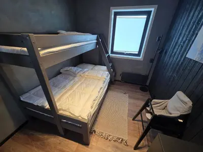 a bunk bed in a room with a chair and a window at Winter cabin with Jacuzzi in Trysil