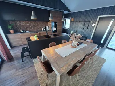 a kitchen and dining room with a wooden table and chairs at Winter cabin with Jacuzzi in Trysil