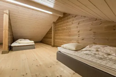 two beds in a room with a wooden wall at Stranda Fjellgrend 3 bedrooms and loft - 80C in Stranda