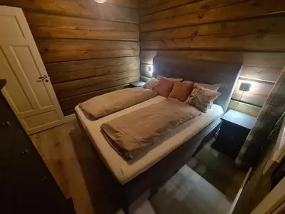 a bedroom with a bed in a wooden cabin at Luster Lodge in Luster
