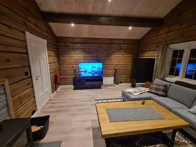 a living room with a couch and a tv at Luster Lodge in Luster