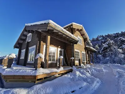 a log cabin in the snow with snow at Luster Lodge in Luster