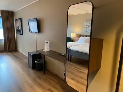 a hotel room with a bed and a mirror at Park Hotel Vossevangen in Vossevangen