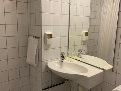 a white bathroom with a sink and a mirror at Park Hotel Vossevangen in Vossevangen