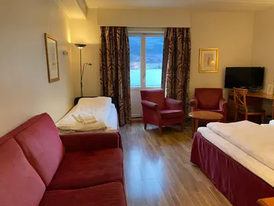 a hotel room with two beds and a couch at Park Hotel Vossevangen in Vossevangen