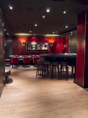 a bar with tables and chairs in a room at Park Hotel Vossevangen in Vossevangen