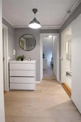 a hallway with a white dresser and a mirror at Art Nouveau in the middle of downtown Ålesund in Ålesund