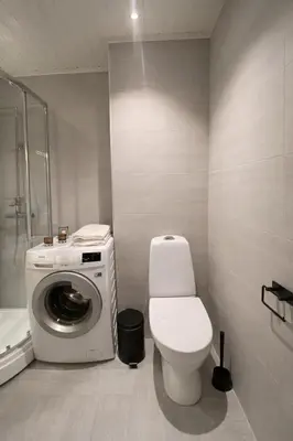 a bathroom with a washing machine and a toilet at Art Nouveau in the middle of downtown Ålesund in Ålesund