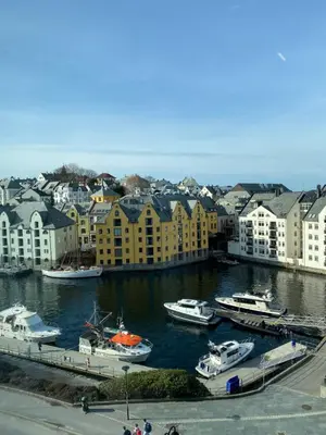 a group of boats docked in a harbor with buildings at Art Nouveau in the middle of downtown Ålesund in Ålesund