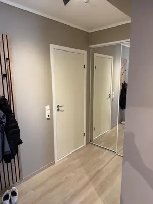 an empty room with two doors and a mirror at Bright and modern city center apartment in Ålesund