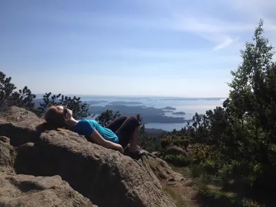 a woman laying on a rock on a mountain at Villa Hagavik, studio apartment Peter