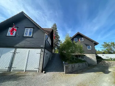 a house with a garage with a red flag in the window at Villa Hagavik, studio apartment Peter
