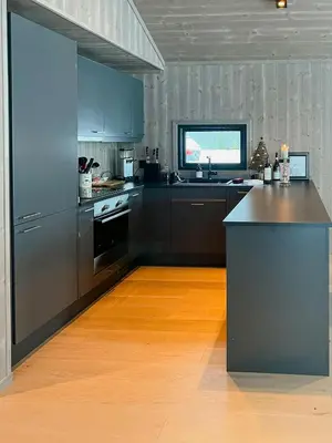 a kitchen with stainless steel appliances and a wooden floor at Opplev Den Unike Stemningen På Golsfjellet in Gol