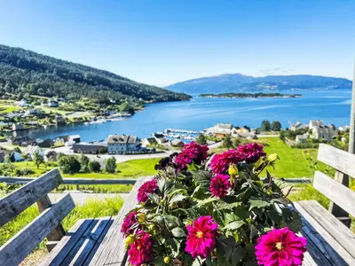 a bouquet of pink flowers sitting on a wooden bench at Apartment Samlen Vasselgård by Interhome in Herand