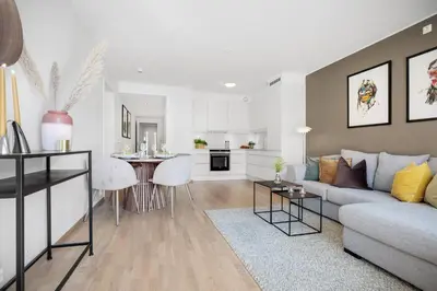 a living room and kitchen with a couch and a table at Modern apartment by the sea - Free parking in Bergen