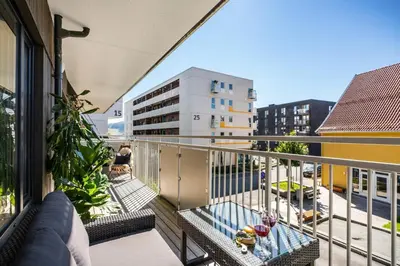 a balcony with a couch and a table at Modern apartment by the sea - Free parking in Bergen