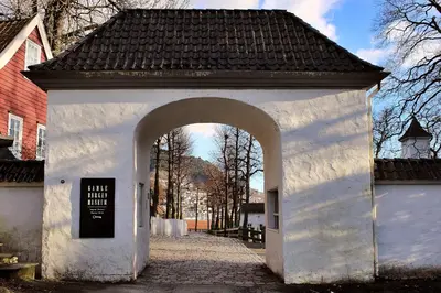 a white building with an arch in a street at Modern apartment by the sea - Free parking in Bergen