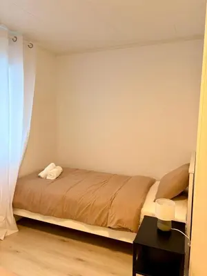 a small bedroom with a bed and a window at Kirkevegen apartment in Brumunddalen