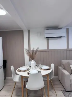 a dining room with a white table and chairs at Kirkevegen apartment in Brumunddalen