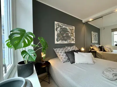 a bedroom with a bed and a potted plant at Exclusive apartment in historical house, Bergen in Bergen