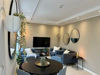 a living room with blue couches and a tv at Exclusive apartment in historical house, Bergen in Bergen