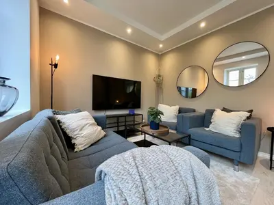 a living room with a blue couch and a tv at Exclusive apartment in historical house, Bergen in Bergen