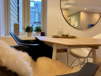 a dining room with a table and a mirror at Eksklusiv leilighet sentralt i Bergen in Bergen