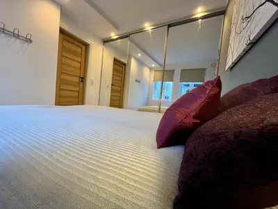 a bedroom with a large white bed with red pillows at Eksklusiv leilighet sentralt i Bergen in Bergen