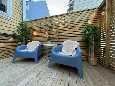 two blue chairs sitting on a patio with plants at Beautiful apartment in Bergen in Bergen
