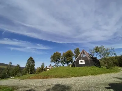 a barn on top of a grassy hill at Hessdalen Ufocamp in Vårhus