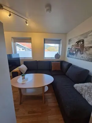 a living room with a blue couch and a table at Modern condominium in Bergen