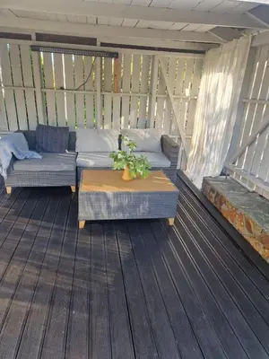 a porch with couches and a table on a deck at Modern condominium in Bergen
