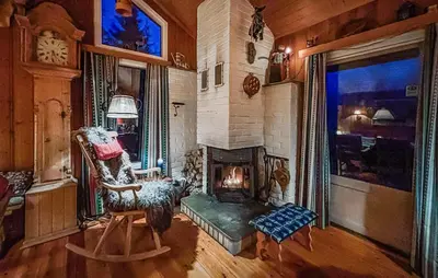 a living room with a fireplace and a chair at 4 Bedroom Nice Home In Trysil in Trysil