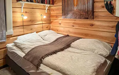a bed in a room with a wooden wall at 4 Bedroom Pet Friendly Home In Svingvoll in Svingvoll
