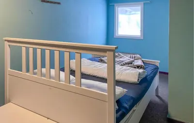 a crib in a room with a blue wall at Cozy Home In Oppdal With House A Mountain View in Oppdal
