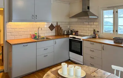 a kitchen with white cabinets and a table with candles at Cozy Home In Oppdal With House A Mountain View in Oppdal