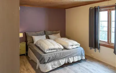 a bed with pillows on it in a room at Cozy Home In Oppdal With House A Mountain View in Oppdal