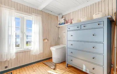 a bathroom with a blue dresser and a toilet at 2 Bedroom Stunning Home In Bjugn in Moen