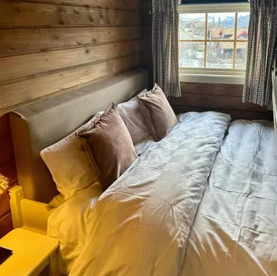 a bed with pillows in a room with a window at Lovely Family Cabin Near Ski Stadium In Beitostølen in Beitostøl