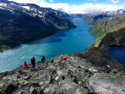 people on the edge of a mountain overlooking a lake at Lovely Family Cabin Near Ski Stadium In Beitostølen in Beitostøl